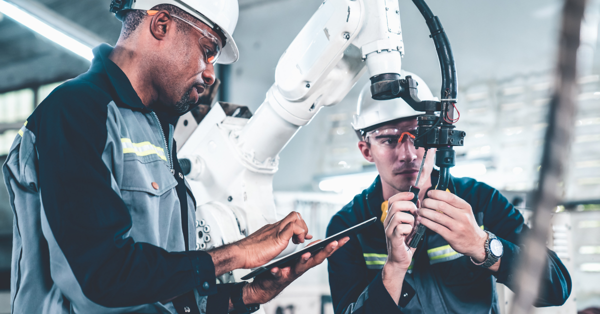 workers at a manufacturing factory with a robot